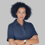 a woman with curly hair wearing a blue shirt