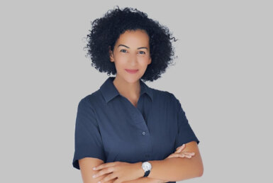a woman with curly hair wearing a blue shirt