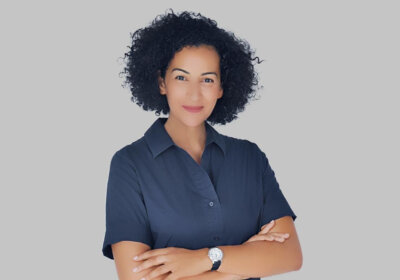 a woman with curly hair wearing a blue shirt